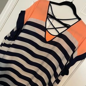 Orange, white, and navy blue flowy blouse with straps in the back.